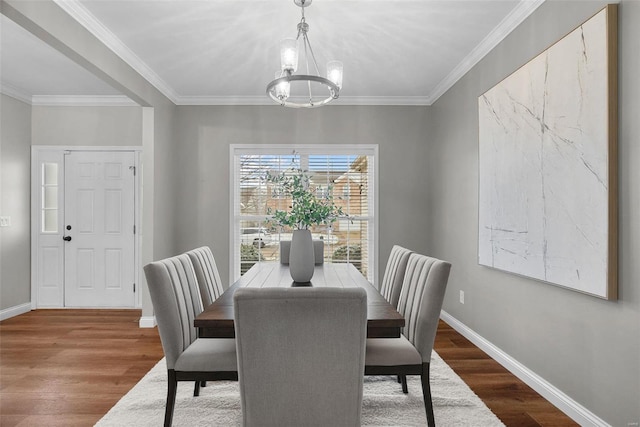 dining space with a chandelier, baseboards, and wood finished floors