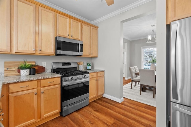 kitchen featuring stainless steel appliances, light brown cabinets, ornamental molding, and wood finished floors