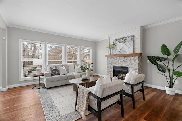 living area featuring crown molding, a fireplace, baseboards, and wood finished floors