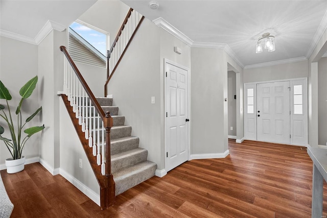 foyer entrance featuring crown molding, baseboards, and wood finished floors