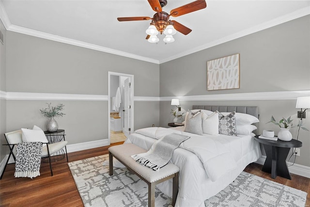 bedroom with ceiling fan, ensuite bathroom, wood finished floors, baseboards, and crown molding