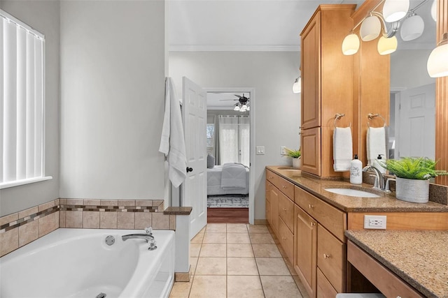 bathroom with crown molding, ceiling fan, vanity, a bath, and tile patterned floors