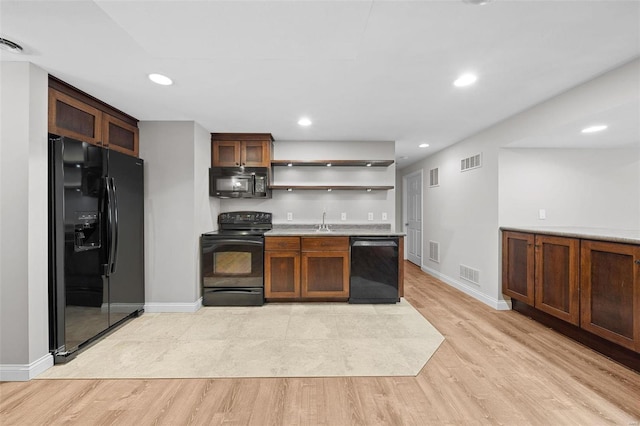 kitchen with open shelves, visible vents, a sink, light wood-type flooring, and black appliances