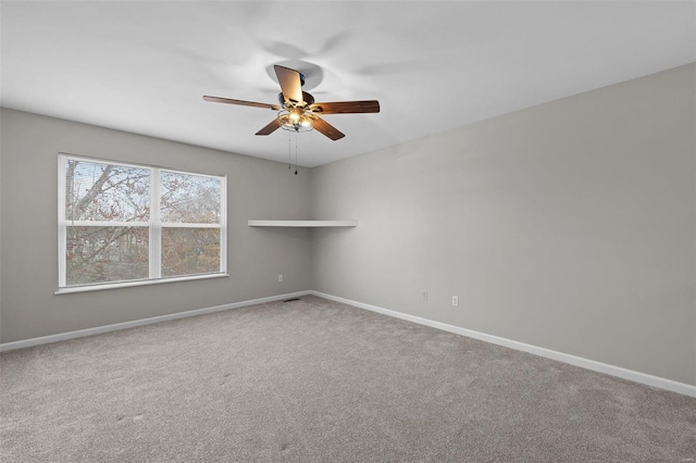 unfurnished room with carpet floors, baseboards, and a ceiling fan