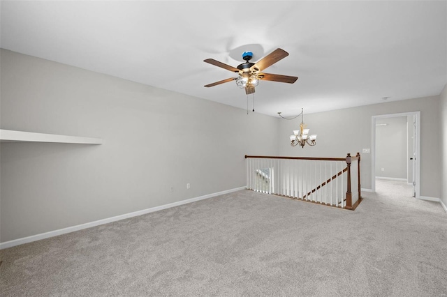 carpeted empty room with baseboards and ceiling fan with notable chandelier