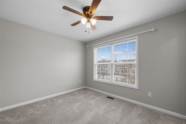 carpeted empty room featuring visible vents, ceiling fan, and baseboards