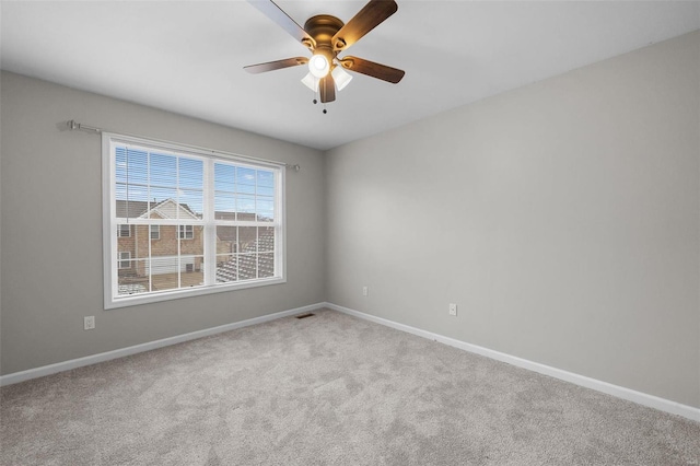 spare room with carpet flooring, visible vents, and baseboards