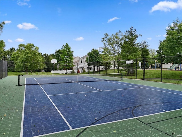 view of tennis court with community basketball court and fence