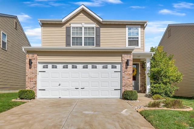 traditional-style house with driveway, a garage, and brick siding