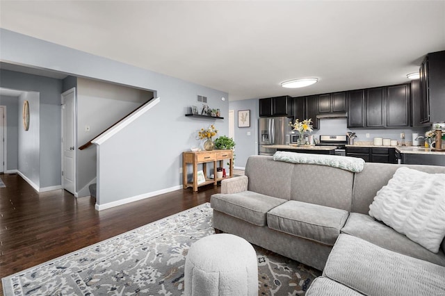 living room with stairway, visible vents, baseboards, and dark wood-style flooring