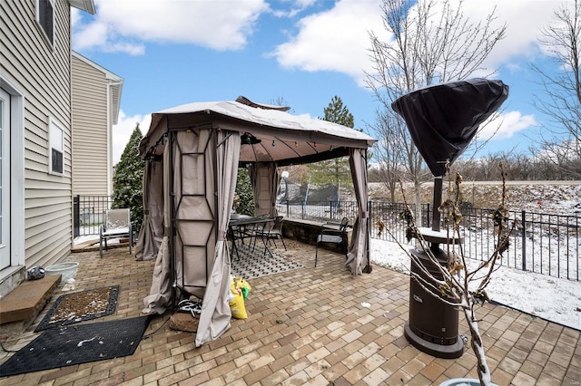 snow covered patio featuring a gazebo and fence