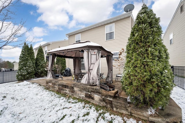 back of property featuring fence, a gazebo, and a patio