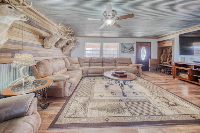 living room featuring a ceiling fan, crown molding, wood finished floors, and wood walls