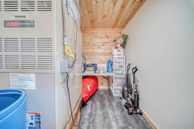 laundry area with baseboards, wood walls, wood ceiling, wood finished floors, and heating unit