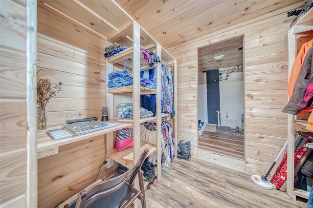 bedroom featuring wood finished floors and wood walls