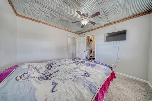 carpeted bedroom featuring crown molding, baseboards, and ceiling fan