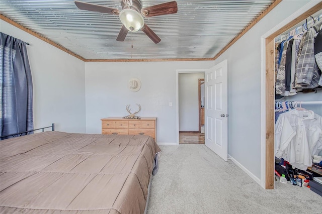 carpeted bedroom featuring a ceiling fan, crown molding, and baseboards