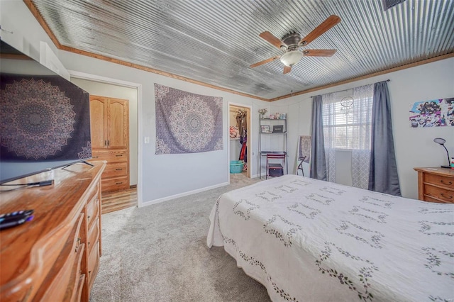 bedroom with a walk in closet, a closet, baseboards, light colored carpet, and ceiling fan