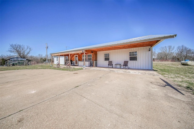 view of front facade featuring driveway and metal roof