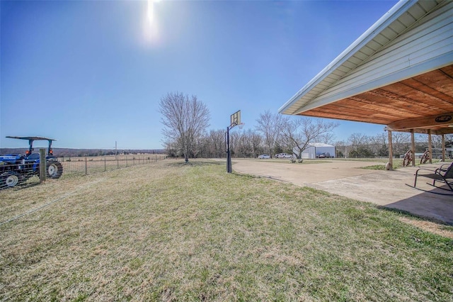 view of yard with a patio, a rural view, and fence