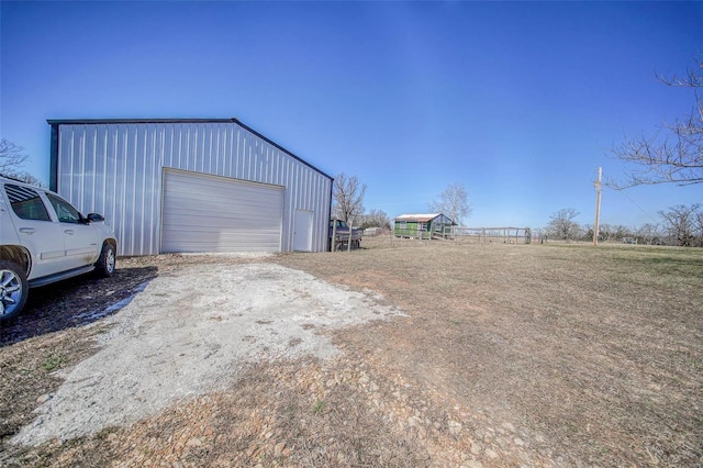 detached garage featuring dirt driveway