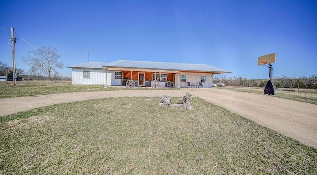 view of front of property featuring metal roof, driveway, covered porch, and a front yard