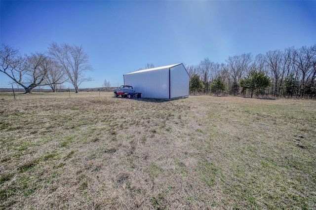 view of yard featuring an outbuilding, a rural view, and a pole building