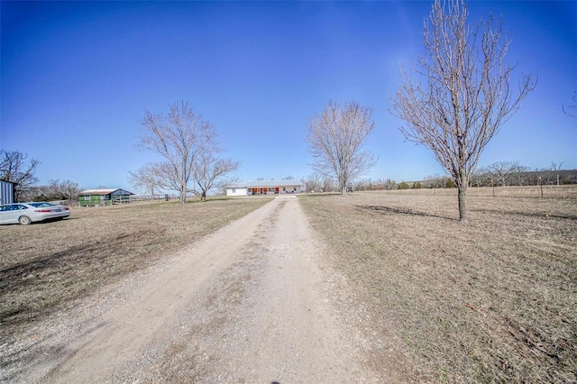 view of street with a rural view and driveway