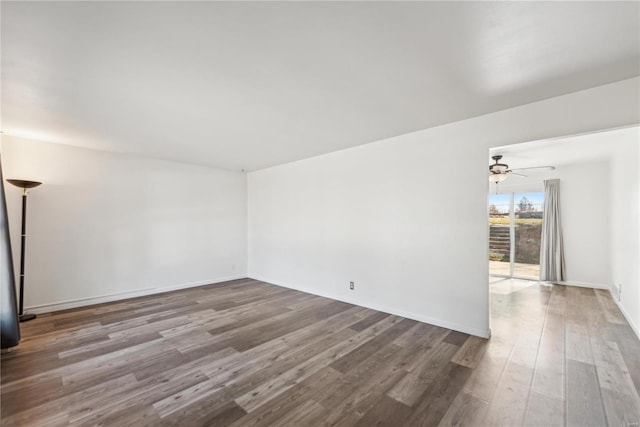 spare room featuring ceiling fan, baseboards, and wood finished floors