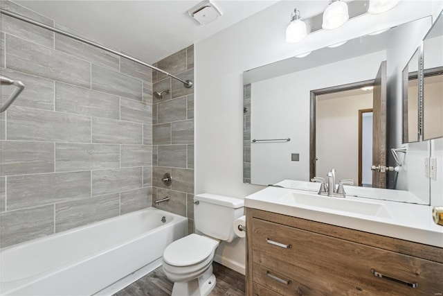 bathroom featuring visible vents, toilet, shower / bathtub combination, wood finished floors, and vanity