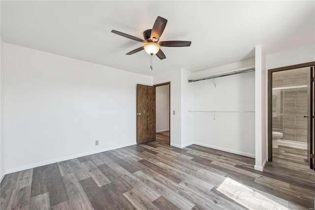 unfurnished bedroom featuring a closet, connected bathroom, ceiling fan, wood finished floors, and baseboards