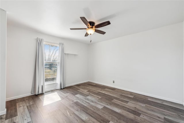 unfurnished room featuring visible vents, wood finished floors, a ceiling fan, and baseboards