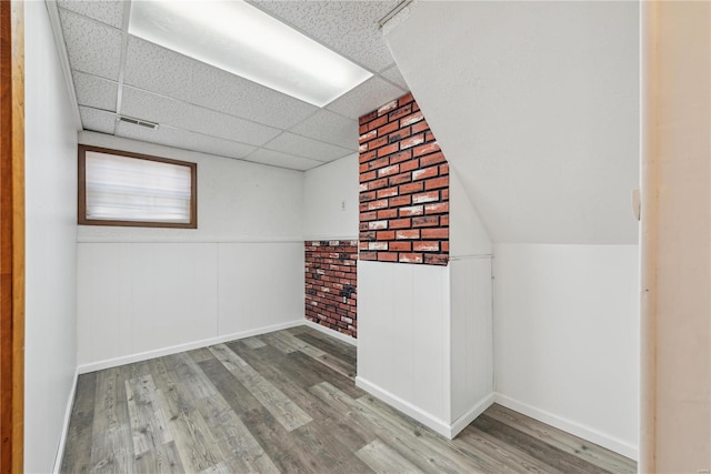 additional living space featuring wood finished floors, visible vents, and baseboards