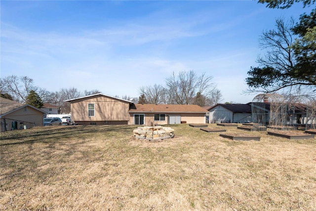 rear view of property with a vegetable garden and a lawn