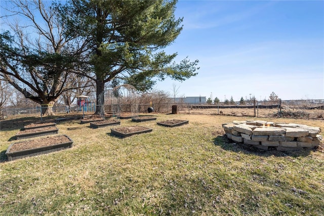 view of yard with a fenced backyard, a vegetable garden, and a fire pit