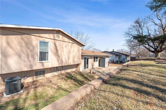 view of side of property with a lawn, a patio area, fence, and central air condition unit