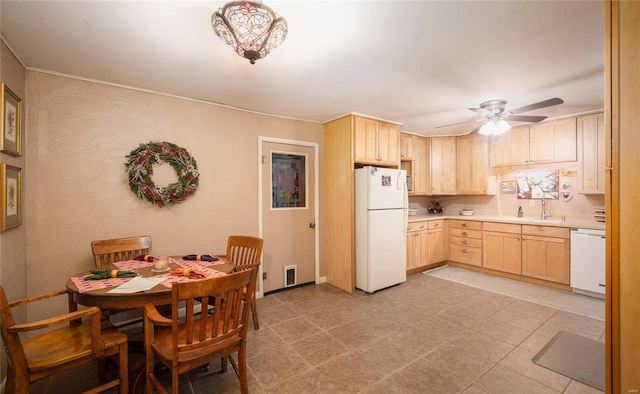 kitchen with light brown cabinetry, white appliances, light countertops, and visible vents