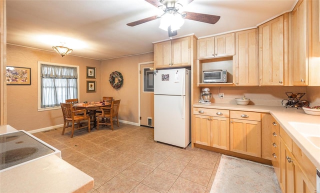 kitchen with ceiling fan, baseboards, light countertops, freestanding refrigerator, and light brown cabinetry