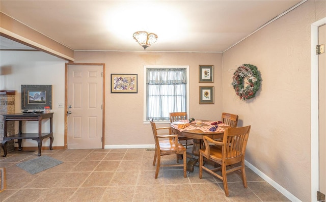 dining space featuring baseboards and light tile patterned floors