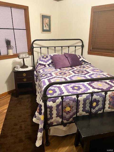 bedroom with baseboards and wood finished floors