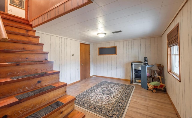 interior space featuring light wood-style flooring, stairs, visible vents, and baseboards