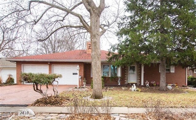 ranch-style home featuring concrete driveway, brick siding, a chimney, and an attached garage