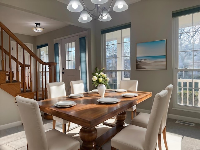 dining room featuring stairway, baseboards, visible vents, and a wealth of natural light