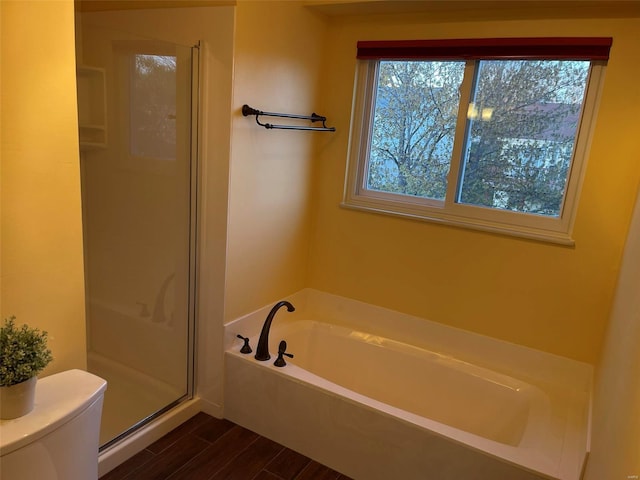 full bath with a wealth of natural light, a stall shower, a garden tub, and toilet