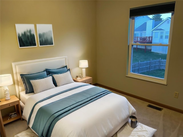 carpeted bedroom with visible vents and baseboards