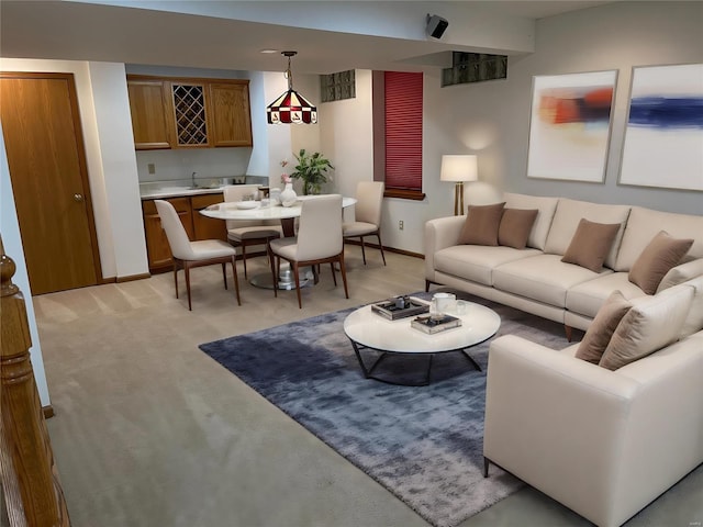 living room featuring wet bar, light carpet, and baseboards