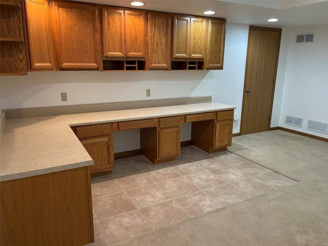 kitchen with light colored carpet, visible vents, open shelves, and built in study area