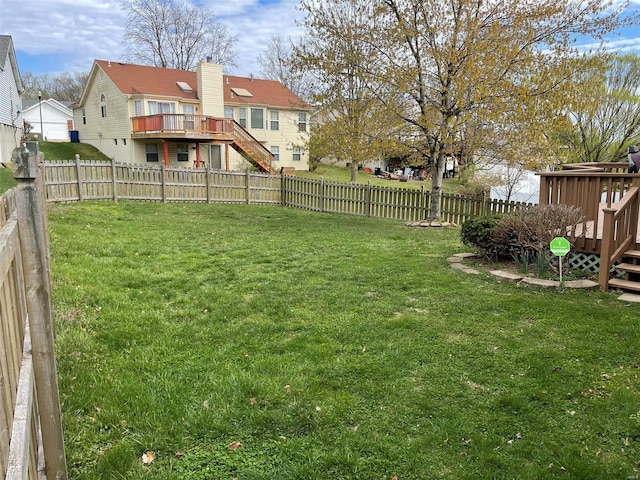 view of yard with stairs, a fenced backyard, a wooden deck, and a residential view