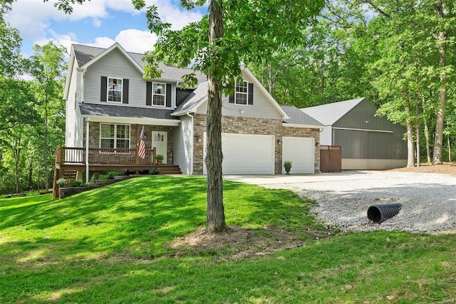 traditional-style home featuring a garage, covered porch, a front yard, and gravel driveway