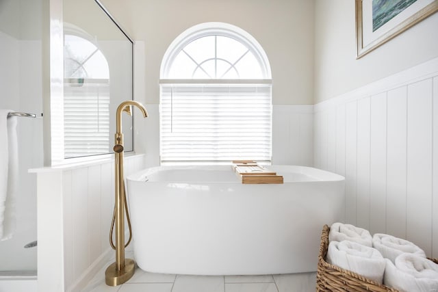 bathroom with wainscoting and a freestanding tub